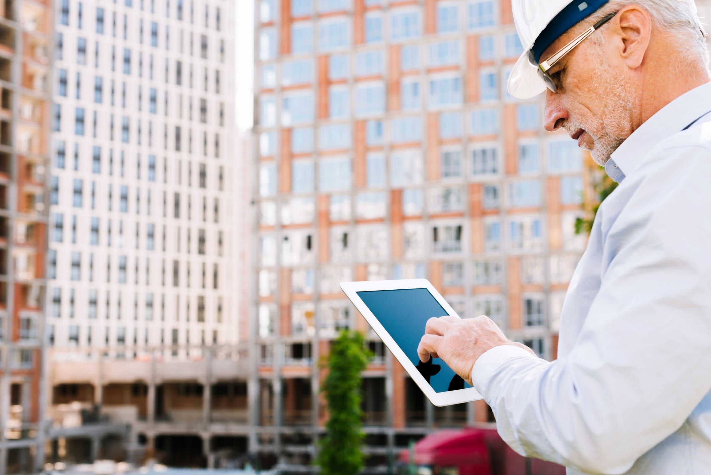 Sachverständige mit Tablet bei der Kontrolle auf einer Baustelle